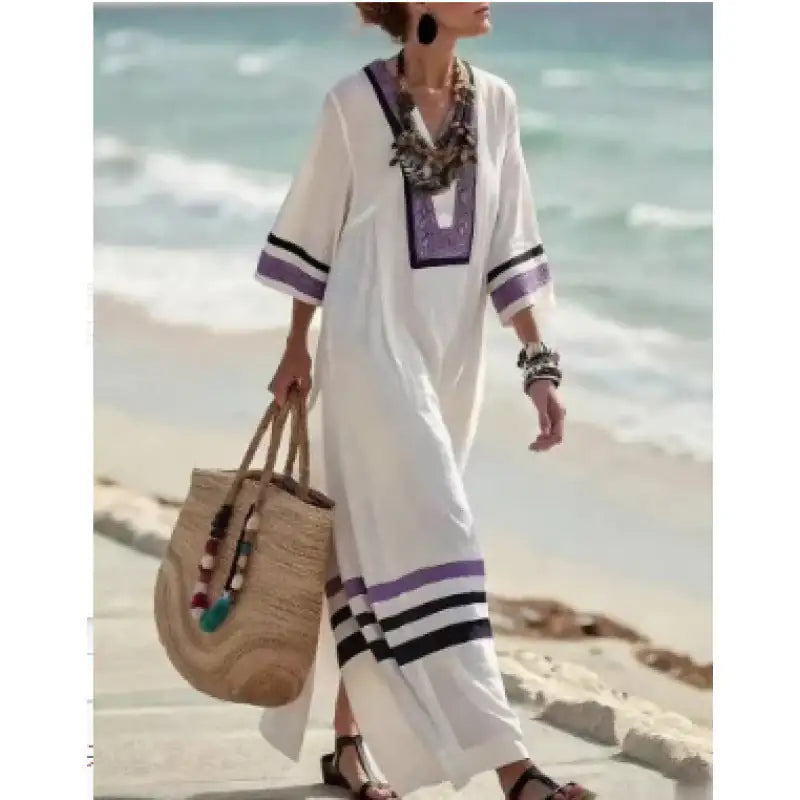 Woman in a white dress with purple accents on a beach