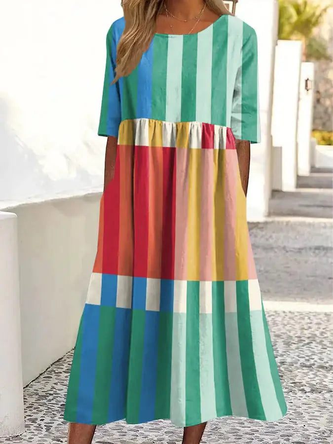 Colorful striped dress worn by a person standing outdoors.