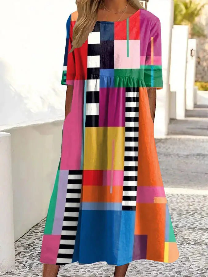 Colorful geometric patterned dress worn by a person outdoors.